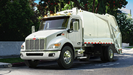 Peterbilt Model 548 Medium Duty White Truck with White Garbage / Refuse Collection Body on Foliage Lined Suburban Street - Thumbnail